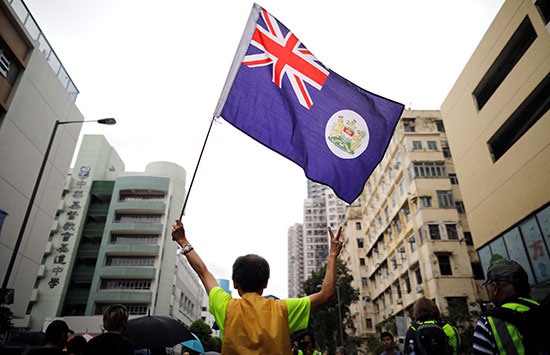 متظاهر يحمل علم الحقبة الاستعمارية لهونج كونج