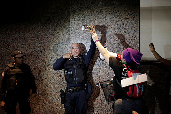 Demonstrators attack a policeman