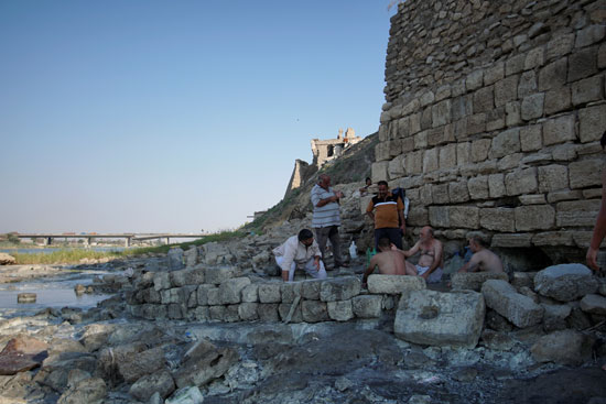 عدد-من-العراقيين-يجلسون-على-ضفاف-نهر-دجلة