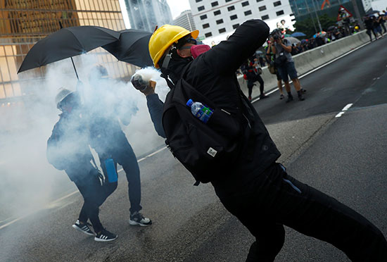 متظاهرون يردون قنابل الغاز على الشرطة