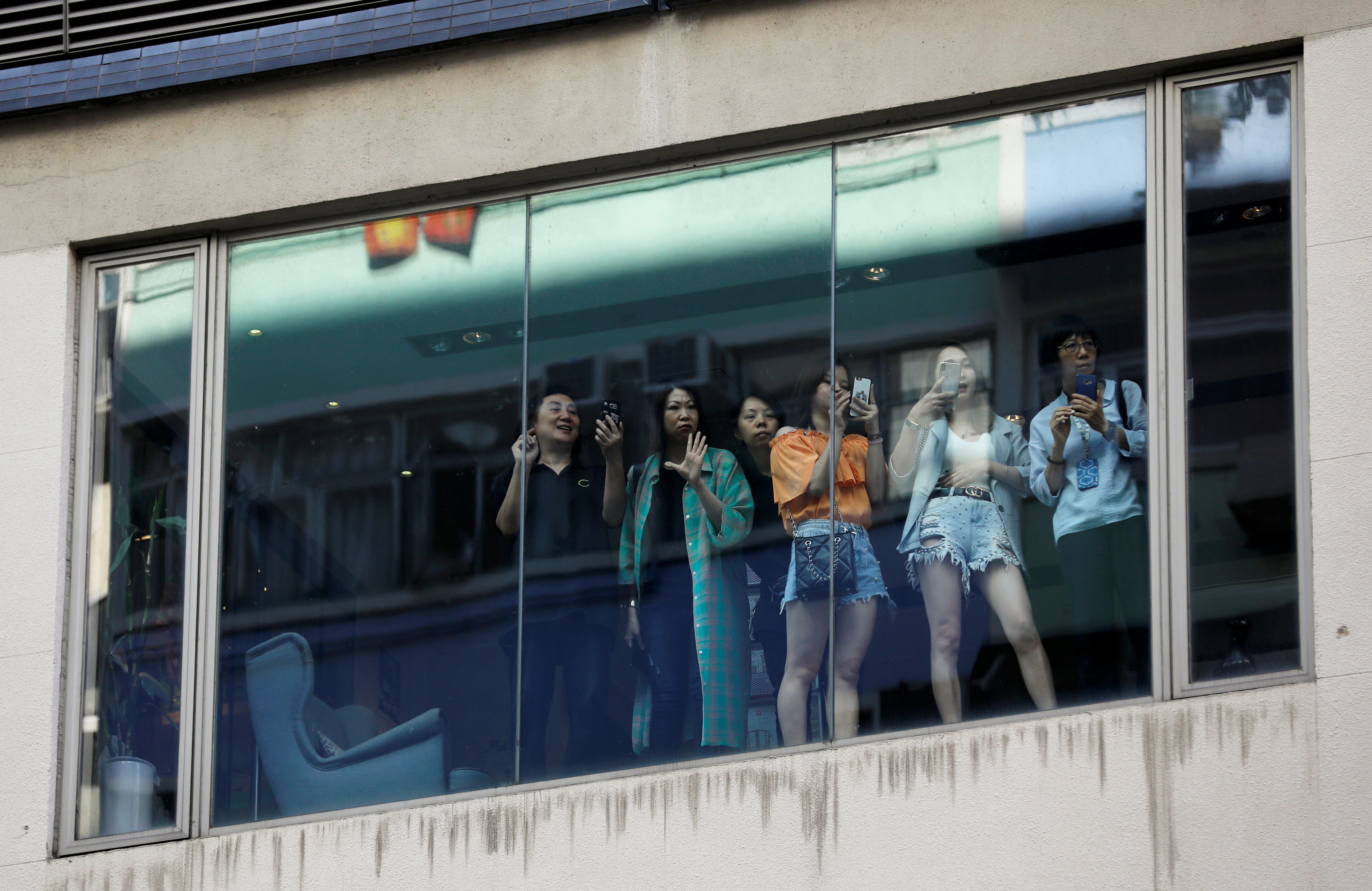 سيدات يصورن المظاهرات من احدى النوافذ