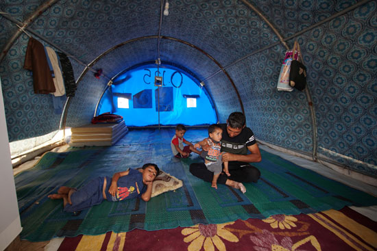 64847-يجلس-مع-أطفاله-في-خيمتهم-في-مخيم-الخازر-للاجئين-على-أطراف-أربيل