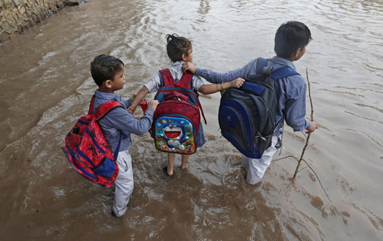 تلاميذ-المدارس-يتجهون-إلى-مدارسهم-أثناء-هطول-الأمطار