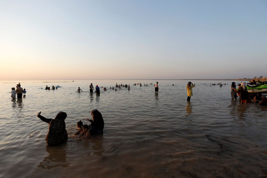 عراقيون يهربون من الحر الشديد بالسباحة فى بحيرة الحبانية (1)
