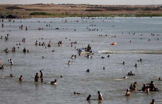 عراقيون يهربون من الحر الشديد بالسباحة فى بحيرة الحبانية (8)