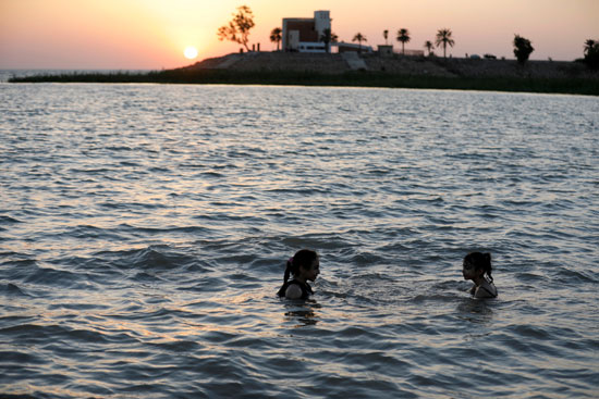 عراقيون يهربون من الحر الشديد بالسباحة فى بحيرة الحبانية (9)