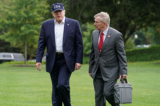 الرئيس الأمريكي دونالد ترامب يمشي مع الأدميرال بيتر جيه براون بعد عودته من كامب ديفيد
