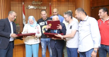 محافظ بورسعيد يقبل المصحف الشريف بعد توقيع البروتوكول