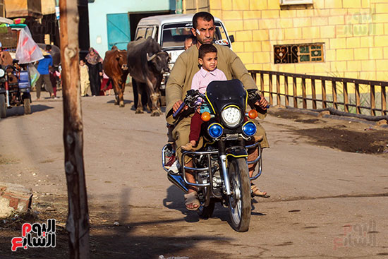 اب يوصل ابنائه للمدرسة علي دراجته النارية