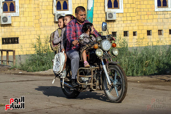 اب يوصل ابنائه للمدرسة علي دراجته النارية (2)