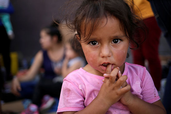 طفلة مكسيسكة تنتظر مع اسرتها العبور للولايات المتحدة