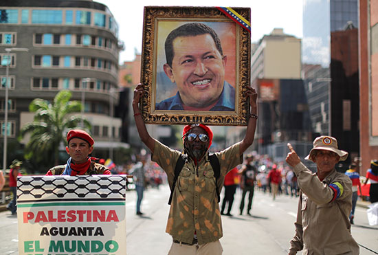متظاهر يحمل صورة لمادورو وآخر يدعم فلسطين