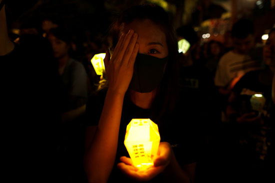 متظاهرة تحمل الشموع