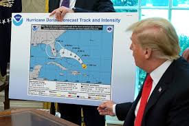 ترامب أمام خريطة لمسار الاعصار دوريان