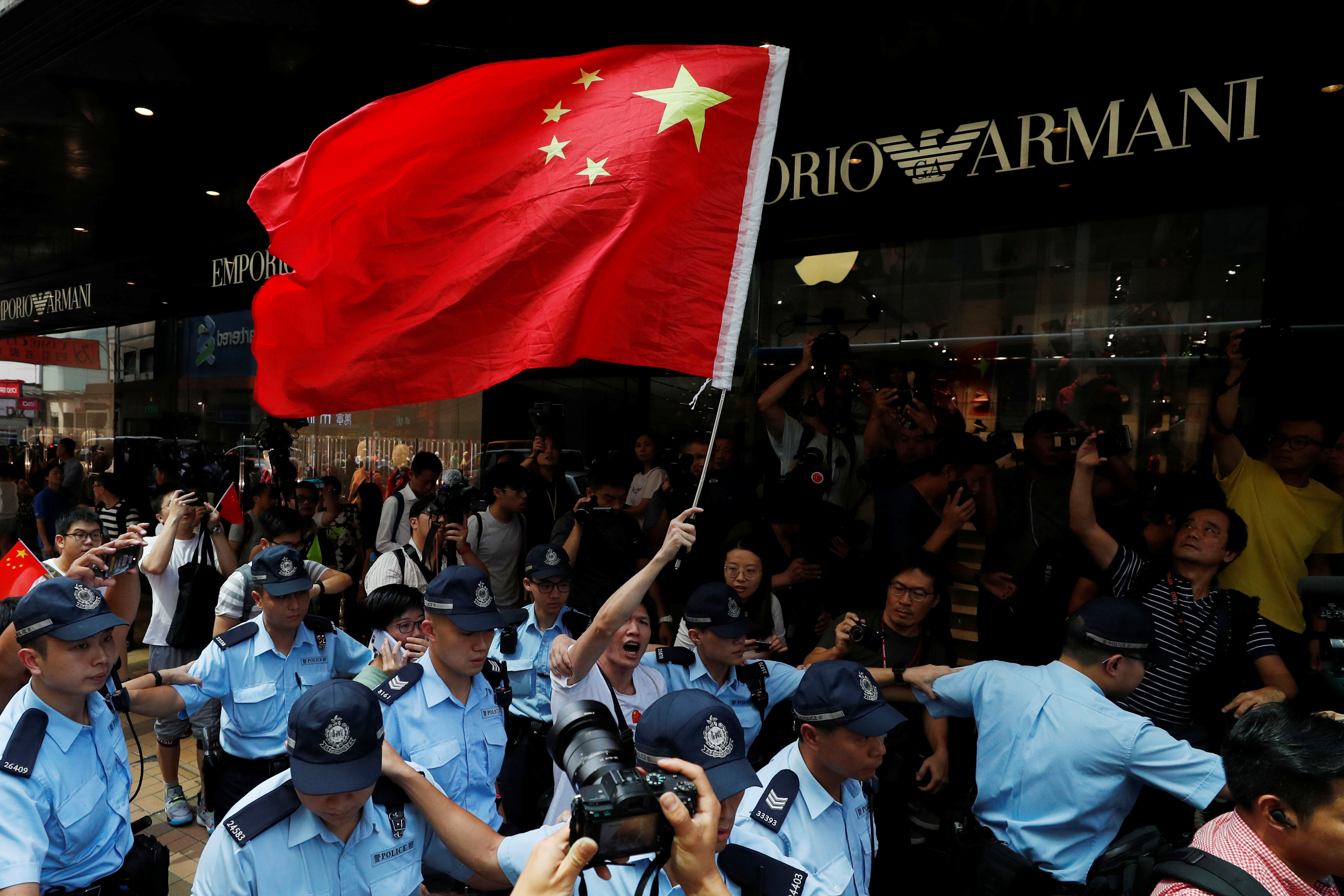 متظاهرة مؤيدة للصين فى حماية الشرطة