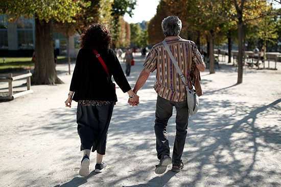 زوجان من كبار السن يسيران في حديقة التويلري