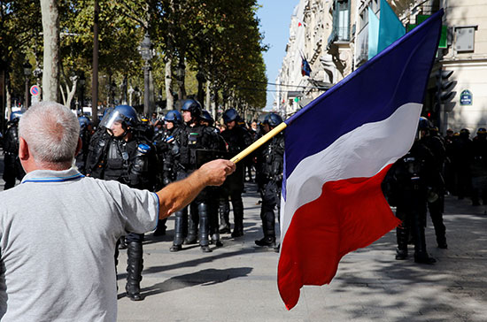 متظاهر يرفع العلم الفرنسى