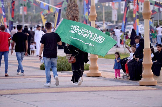 مواطنون-سعوديون-يحملون-علم-المملكة-اثناء-احتفالاتهم-باليوم-الوطنى