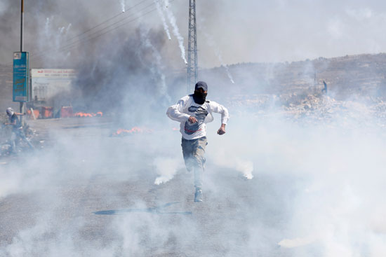 فلسطينى-تلاحقه-قنابل-الغاز-الإسرائيلية