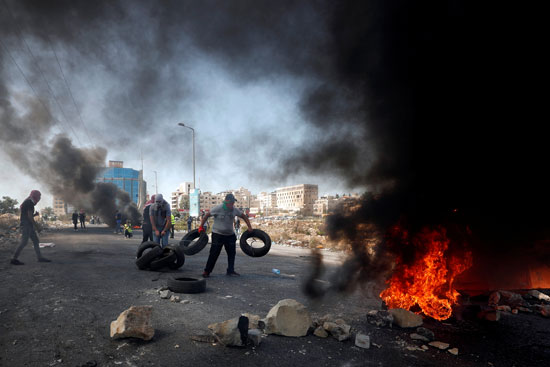 فلسطينيون-يشعلون-النار-فى-إطارات-السيارات