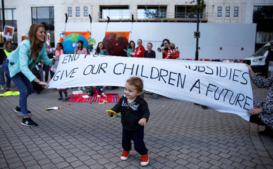 طفل-يلهو-أمام-لافتة-مكتوب-عليها-اعطوا-الحق-لأطفالنا-فى-المستقبل