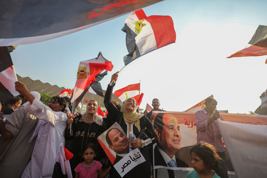 سيدات يرفعن علم مصر وصور الرئيس