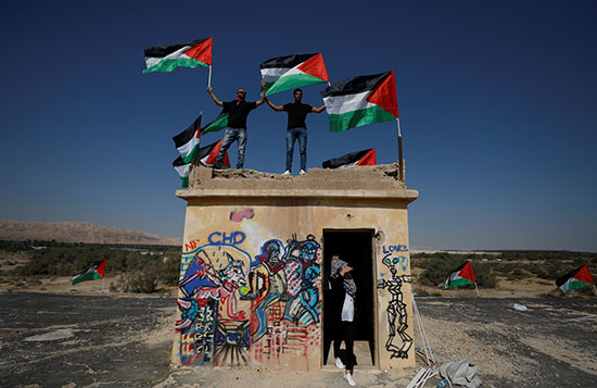متظاهرون يرفعون العلم الفلسطينى