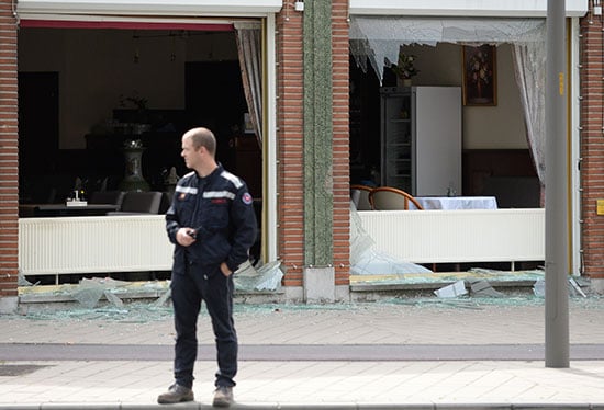 رجل شرطة يقف أمام أثار الانفجار