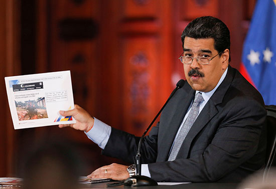 مادورو يرفع لافتة لشرح أمر خلال المؤتمر الصحفى فى كراكاس