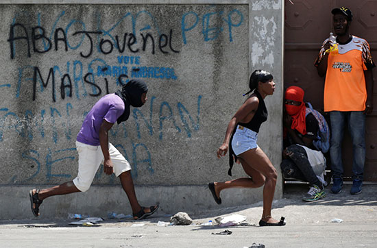 متظاهرة تركض خلال مظاهرات هايتى