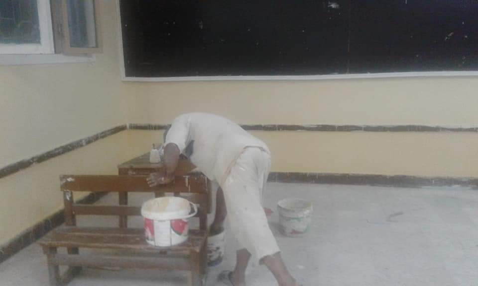 مدير المدرسة أثناء طلائه لجدرانها (3)