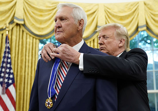 Trump puts the medal on the basketball player's chest