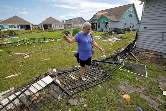 سيدة تتفقد منزلها بعد الإعصار