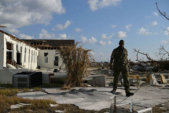 جندى من الجيش الباهامى يتفد ما خلفه الإعصار