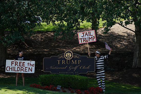 متظاهر يرفع لافتة ضد ترامب