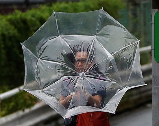 مواطن يحمل مظلة للحماية