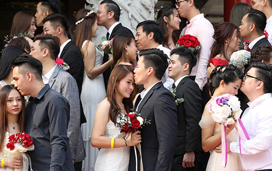 تبادل القبلات خلال حفل الزفاف الجماعى