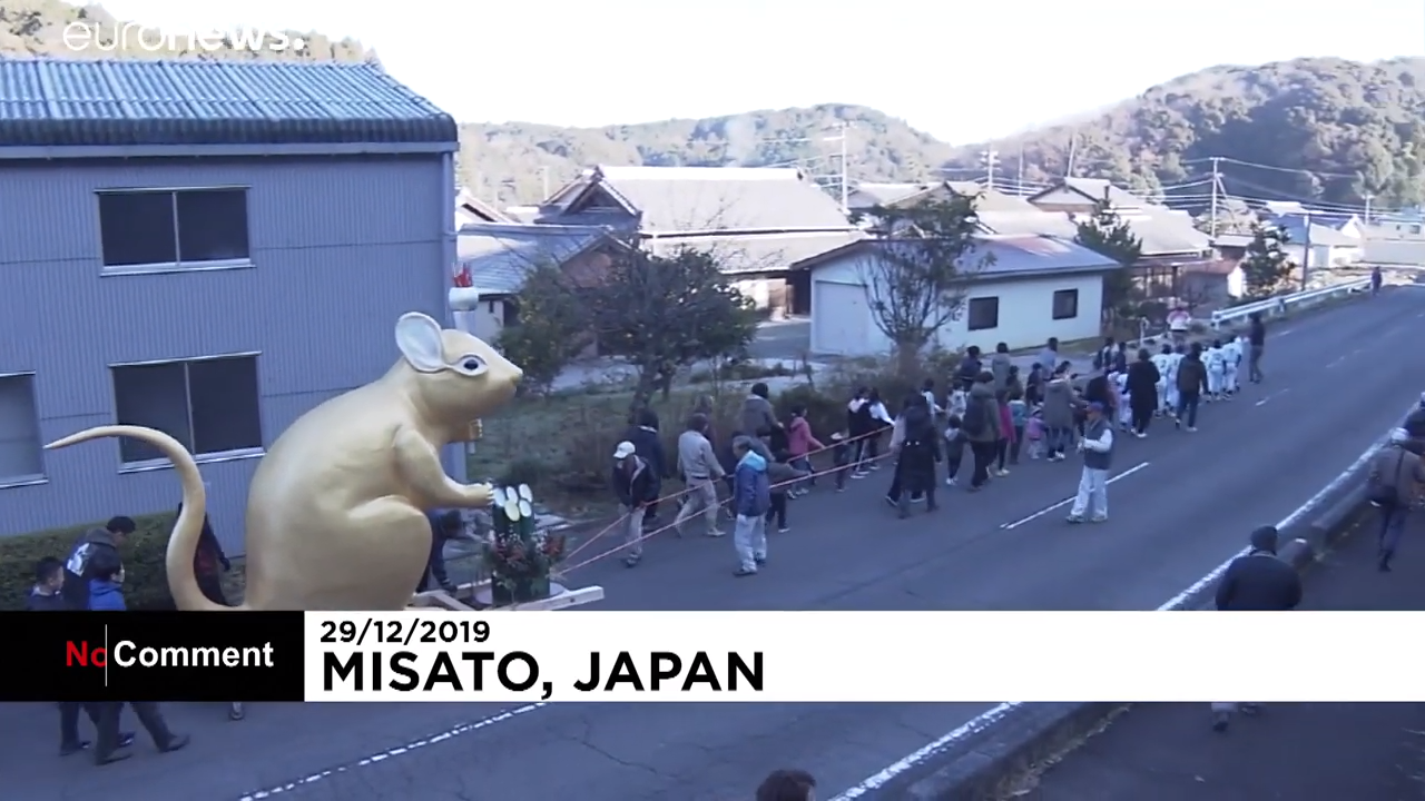 الشباب اليابانى يجر تمثال الفأر الذهبى