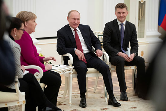 الرئيس الروسي فلاديمير بوتين يبتسم أثناء محادثاته مع المستشارة الألمانية أنجيلا ميركل