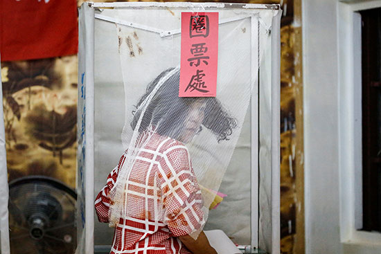 ناخبة تايوانية في كشك الاقتراع خلال الانتخابات العامة