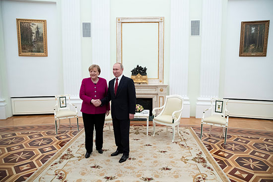 يصافح الرئيس الروسي فلاديمير بوتين والمستشارة الألمانية أنجيلا ميركل أ في الكرملين