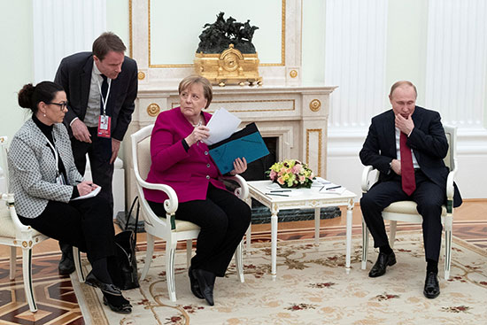 المستشارة الألمانية أنجيلا ميركل تحمل أوراقًا خلال محادثاتها مع الرئيس الروسي فلاديمير بوتين