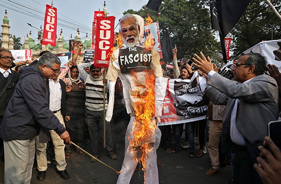 نشطاء من مركز الوحدة الاشتراكية في الهند يحرقون دمية تصور رئيس الوزراء الهندي مودى خلال مظاهرة في كولكاتا