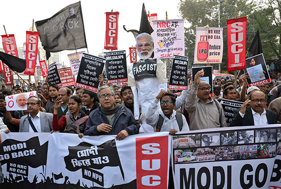 نشطاء يحملون دمية تصور رئيس الوزراء الهندي مودى خلال احتجاج على زيارته لولاية كولكاتا