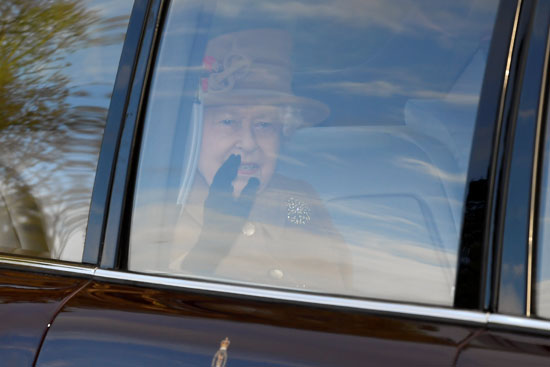 ملكة بريطانيا إليزابيث تلوح بيدها من خلف شباك السيارة