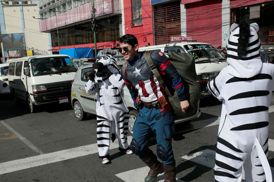 يمزحون مع رجل يرتدي زي شخصية الكتاب الهزلي كابتن أميركا في أحد شوارع لاباز