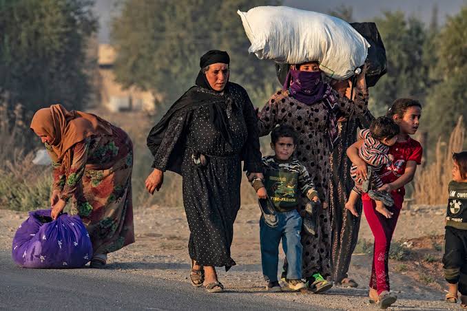 سيدة سورية تسير خلال نزوحها جراء العنف التركى
