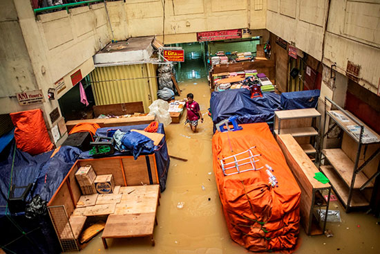 رجل يسير في منطقة ضربتها الفيضانات في جاكرتا بأندونيسيا