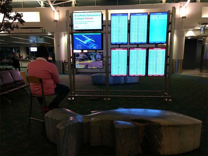 شاب يمارس ألعاب الفيديو على شاشات المطار