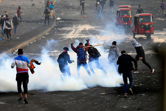 الشرطة تلقى القنابل المسيلة للدموع على المتظاهرون فى بغداد